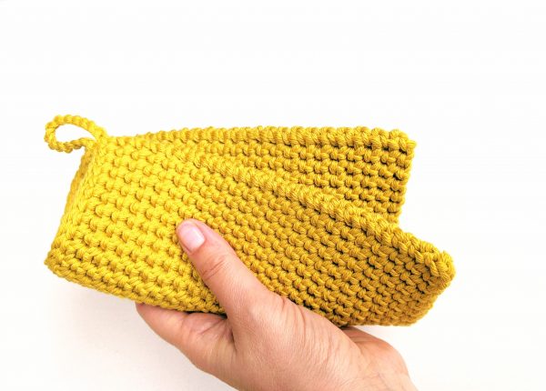 hand holding a yellow potholder 