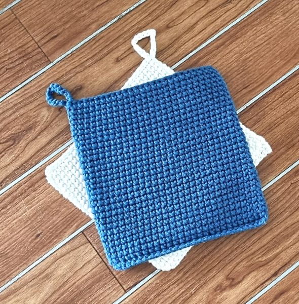 two cross stitch crochet potholders in blue and white