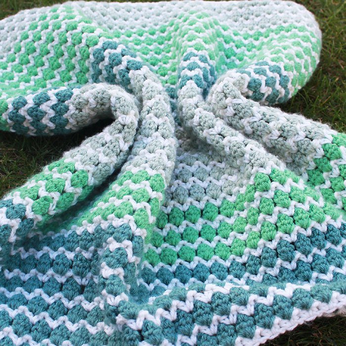 couverture de couleur verte, blanche et bleue