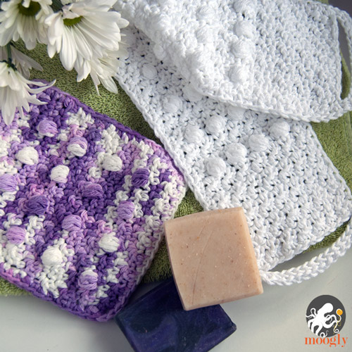 purple and white crochet washcloths with soap and flowers