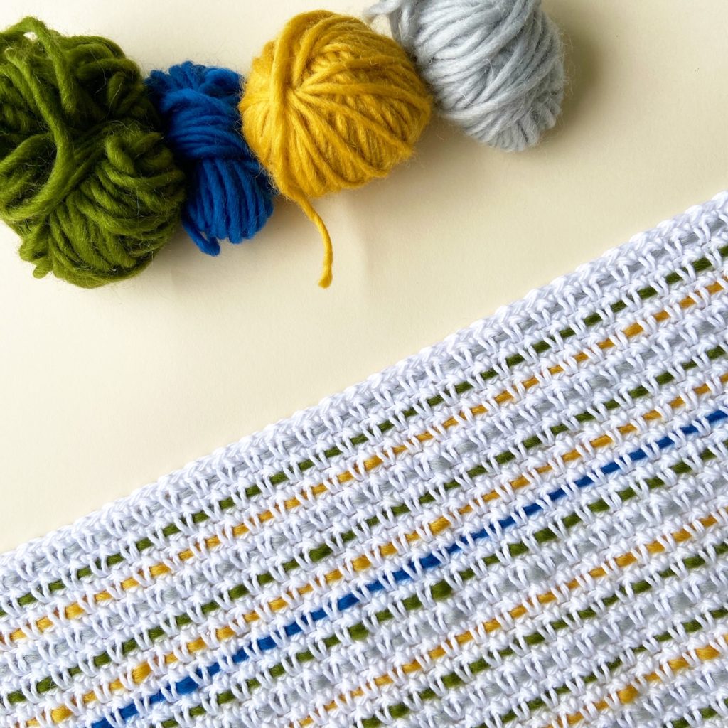 couverture au crochet avec 4 pelotes de laine de différentes couleurs