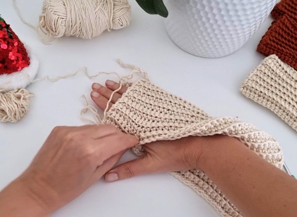 one hand wrapped around with crochet fabric to measure for size