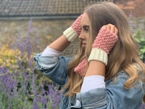 a girl wearing white/pink coloured fingerless gloves while being outside in nature