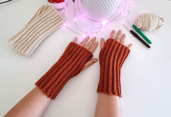 two copper coloured fingerless gloves on white background