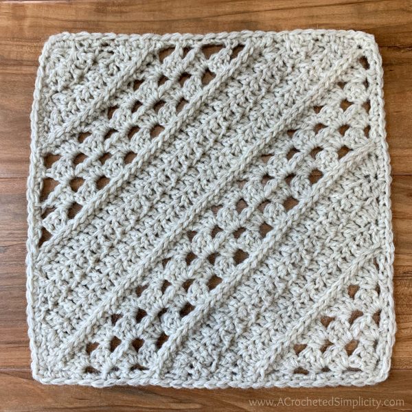 natural coloured crochet square on wooden background