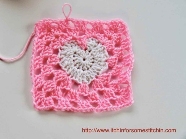 pink heart shaped crochet square on white background