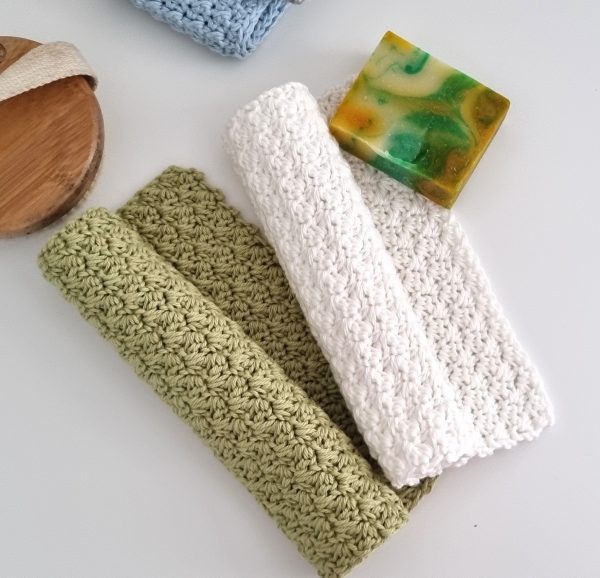 two crochet washcloths in green and white