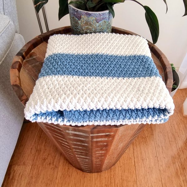 Folded crochet blanket on a wooden coffee table