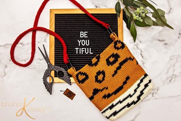 A little brown crochet purse with a zebra-like pattern.