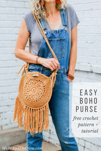 A woman in jeans overalls with a brown round crochet bag slung over her shoulder.