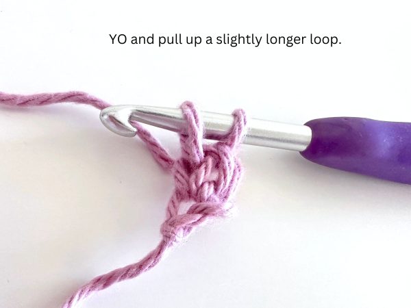 Two loops on hook, demonstrating the seventh step of the foundation single crochet stitch.