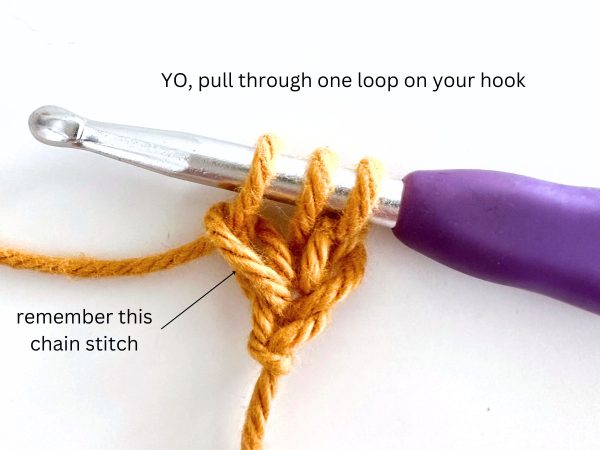 Three loops on a hook, using orange yarn and a purple hook, demonstrating the third step of the foundation half double crochet stitch.