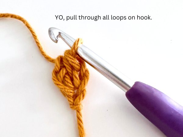 One loop on a hook and one completed foundation half double crochet stitch, created with orange yarn and a purple hook, illustrating the fourth step of the stitch