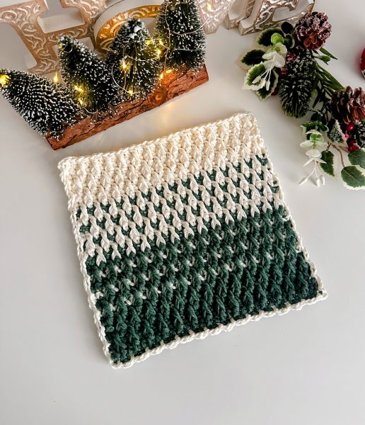Crochet trivet in green and white colors displayed on a white background, styled as festive Christmas decor.
